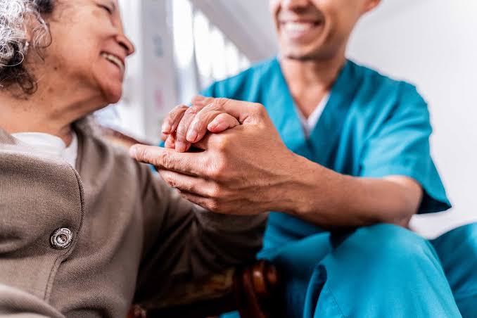 Healthcare professional supporting an older patient
